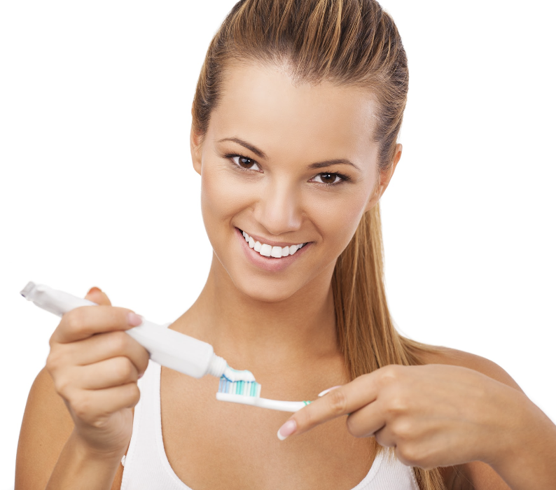 woman holding a toothbrush and toothpaste