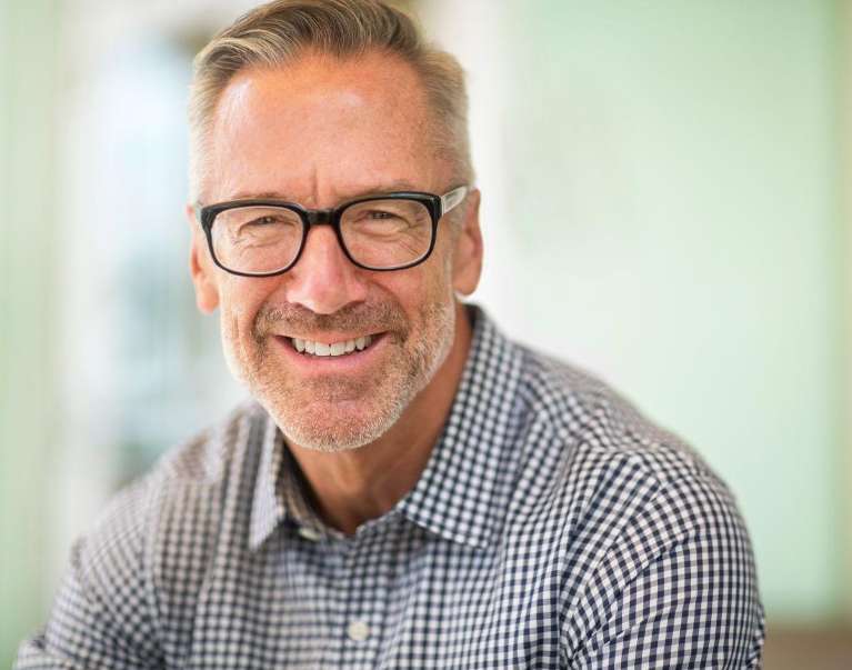 man with dental implants wearing glasses